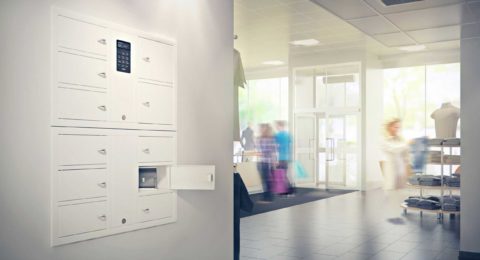 Valuables cabinet 7004 S in the System series with a 7006 S in the Expansion series. Mounted in a wall recess with one compartment open containing a bag in a shop premises.